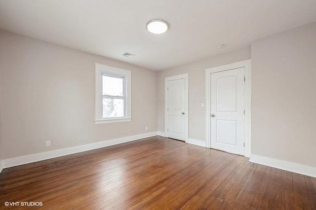 unfurnished bedroom with dark hardwood / wood-style floors