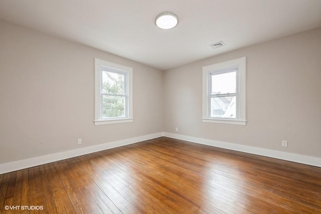 spare room with hardwood / wood-style flooring and a wealth of natural light