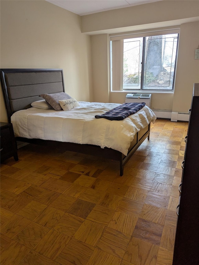 bedroom with a baseboard radiator and light parquet flooring