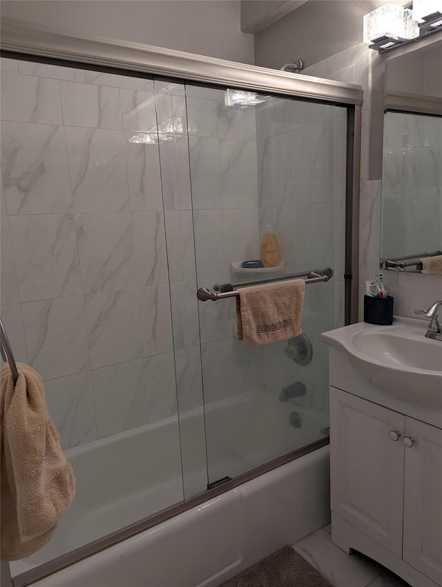 bathroom featuring vanity and shower / bath combination with glass door