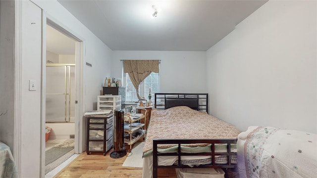 bedroom featuring connected bathroom and wood finished floors