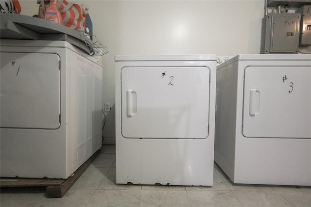 laundry room with electric panel, separate washer and dryer, and light tile patterned flooring