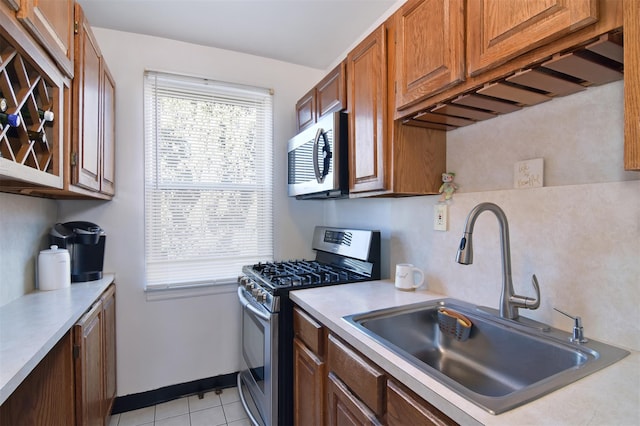 kitchen featuring sink, light tile patterned floors, and stainless steel appliances