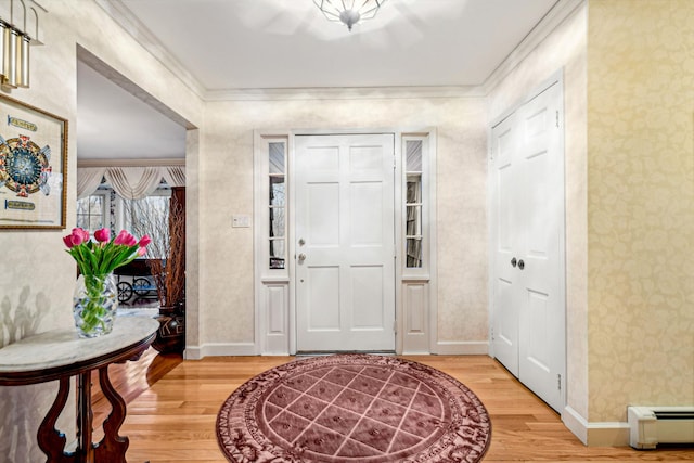 foyer entrance with crown molding, hardwood / wood-style floors, and a baseboard heating unit