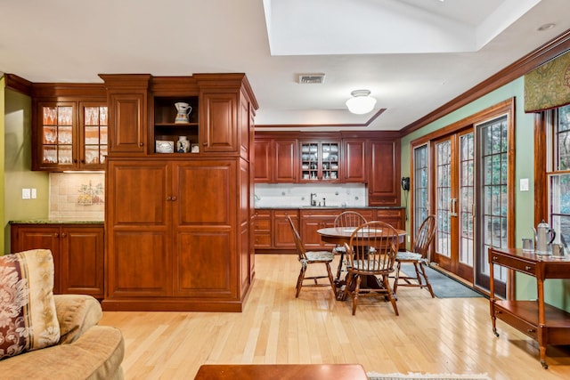 dining room with ornamental molding and light wood-type flooring