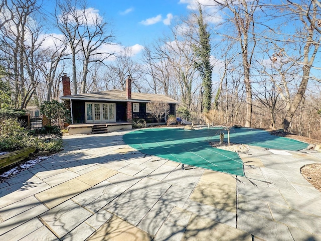 view of swimming pool with french doors and a patio area