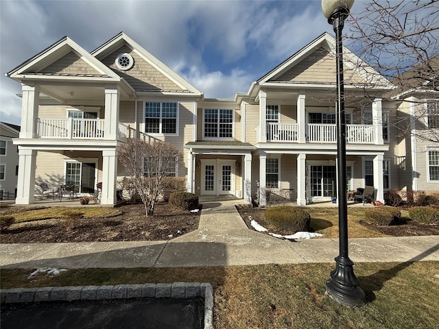 view of front facade with a balcony and french doors