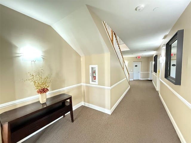 hall with vaulted ceiling and carpet flooring