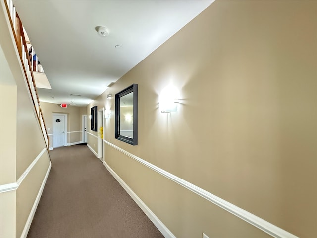 corridor featuring dark colored carpet