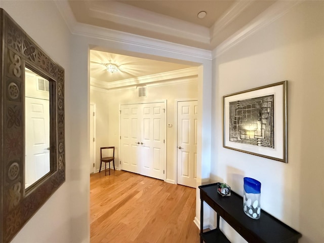 hallway featuring crown molding and light hardwood / wood-style flooring