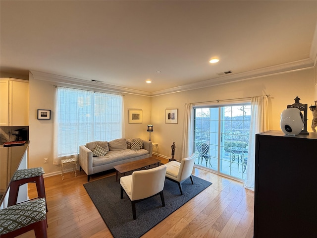 living room with crown molding and light hardwood / wood-style floors