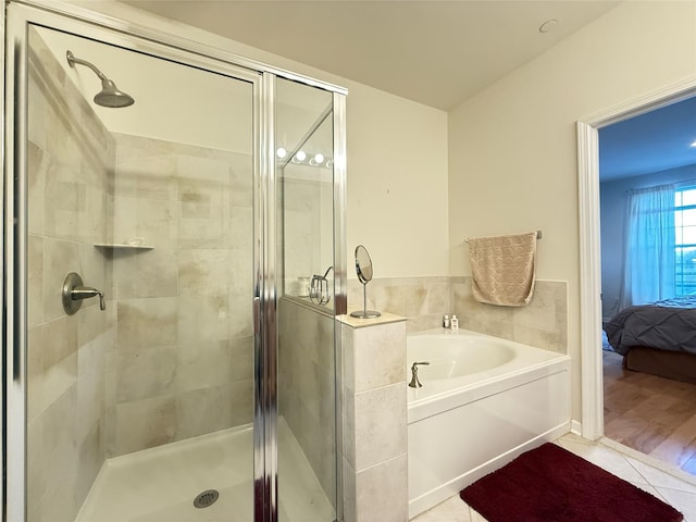 bathroom featuring shower with separate bathtub and tile patterned flooring