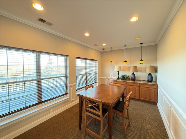 carpeted dining room with ornamental molding