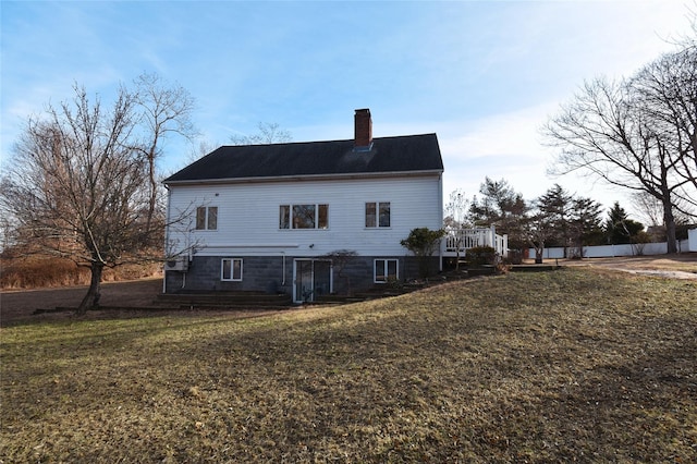 back of property featuring a wooden deck and a yard