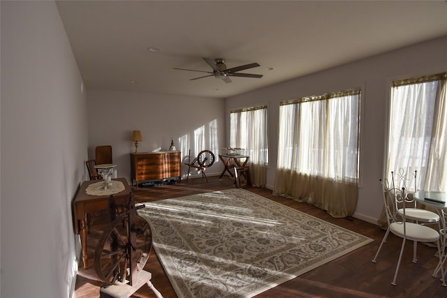 living area with ceiling fan and dark hardwood / wood-style flooring