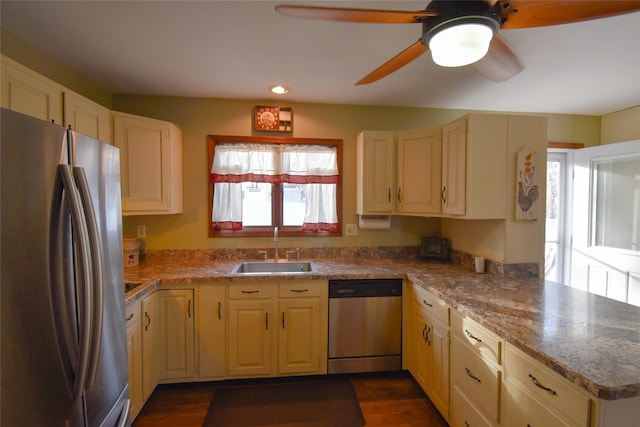 kitchen featuring sink, light stone counters, appliances with stainless steel finishes, dark hardwood / wood-style floors, and kitchen peninsula