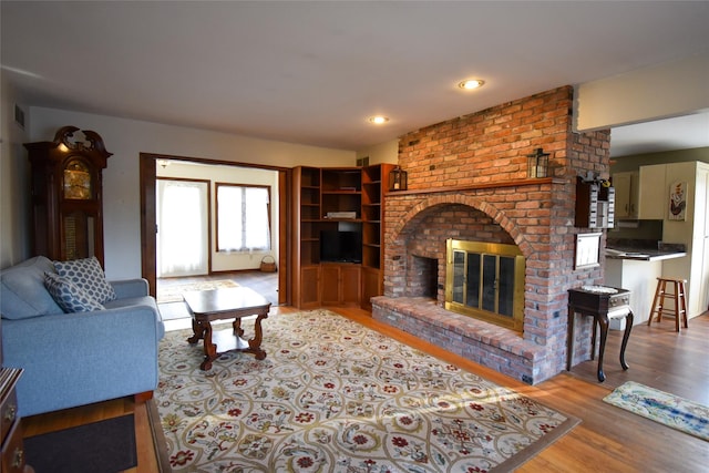 living room with a fireplace and light wood-type flooring