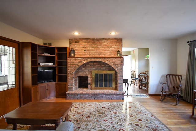 living room featuring a fireplace and light hardwood / wood-style floors