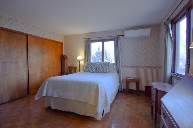 bedroom with multiple windows, an AC wall unit, and parquet flooring