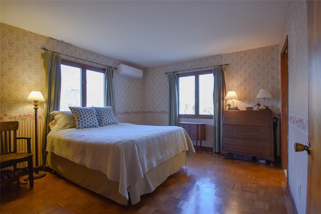 bedroom with dark parquet floors and a wall unit AC