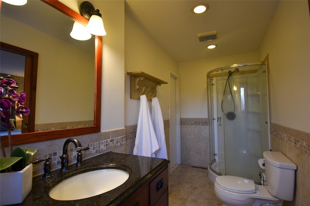 bathroom with vanity, tile walls, an enclosed shower, and toilet