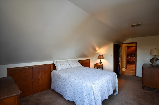 bedroom with vaulted ceiling and dark carpet