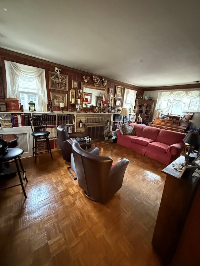 living room featuring parquet flooring and a brick fireplace