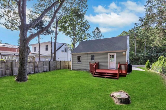 back of property with a wooden deck and a yard