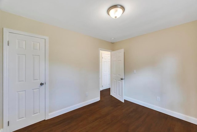 spare room featuring dark wood-type flooring