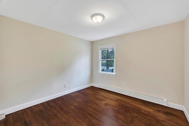 spare room featuring a baseboard radiator and dark hardwood / wood-style floors