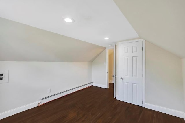 additional living space with baseboard heating, lofted ceiling, and dark hardwood / wood-style flooring