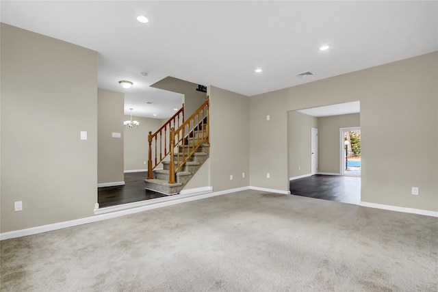 carpeted empty room with a notable chandelier