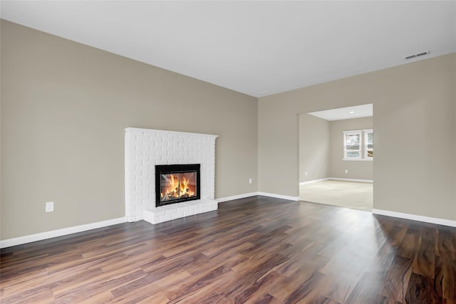 unfurnished living room featuring a fireplace and hardwood / wood-style floors