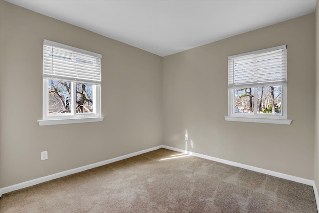 carpeted spare room featuring a healthy amount of sunlight