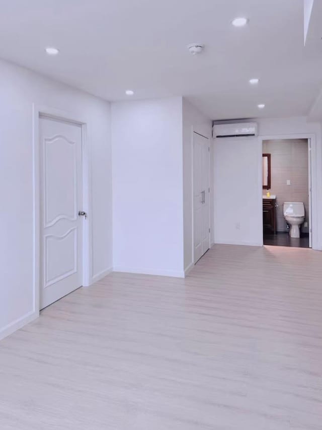 empty room featuring light hardwood / wood-style flooring and a wall mounted AC