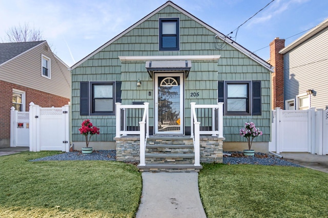 bungalow-style home featuring a front lawn