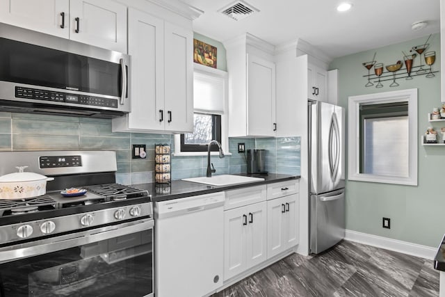 kitchen featuring tasteful backsplash, stainless steel appliances, sink, and white cabinets