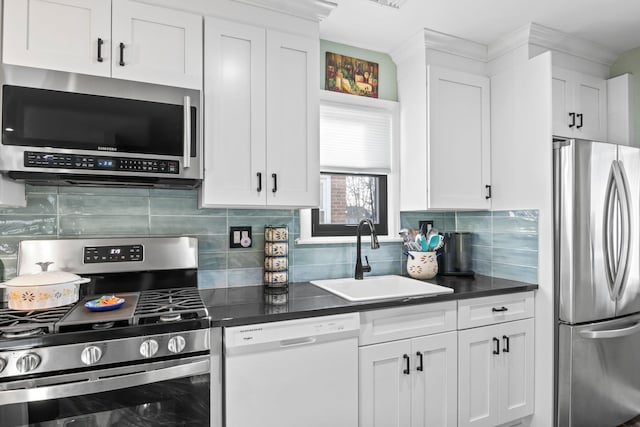 kitchen featuring stainless steel appliances, sink, decorative backsplash, and white cabinets