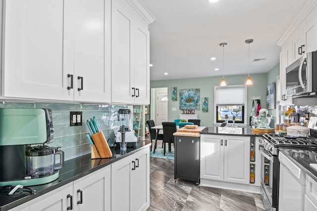 kitchen with hanging light fixtures, appliances with stainless steel finishes, white cabinets, and backsplash