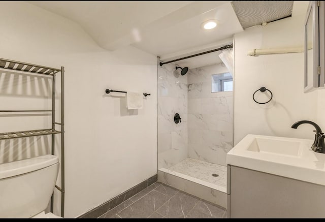 bathroom with vanity, tiled shower, and toilet