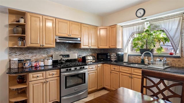 kitchen with sink, light brown cabinets, stainless steel gas range, and backsplash