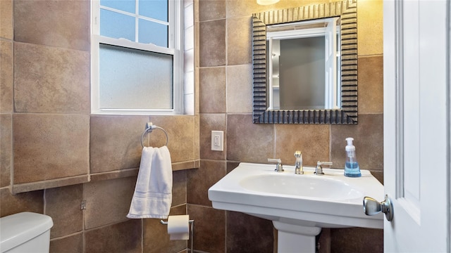 bathroom with sink, tile walls, backsplash, a healthy amount of sunlight, and toilet