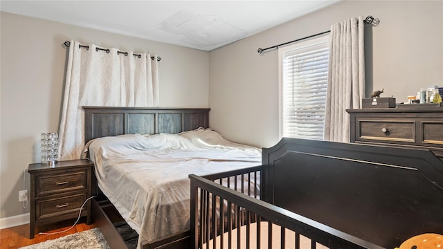 bedroom with dark hardwood / wood-style flooring