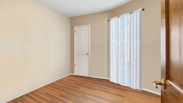 spare room featuring wood-type flooring