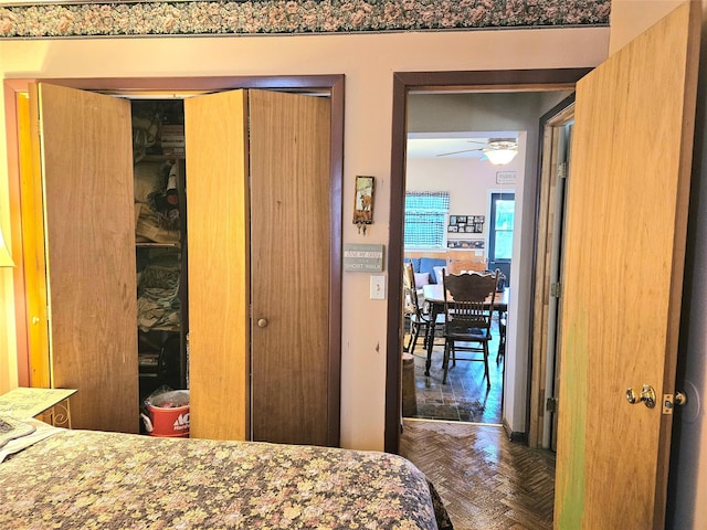 bedroom with dark parquet floors and a closet