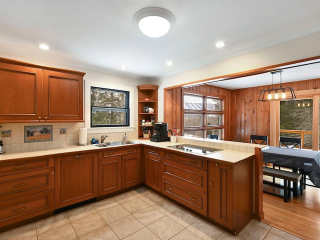 kitchen with sink, tasteful backsplash, decorative light fixtures, kitchen peninsula, and black electric stovetop