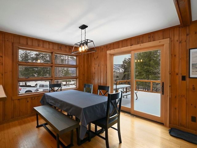 dining room featuring light hardwood / wood-style floors and wood walls