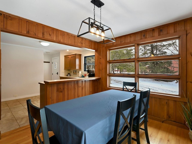 dining area with wooden walls and light hardwood / wood-style floors