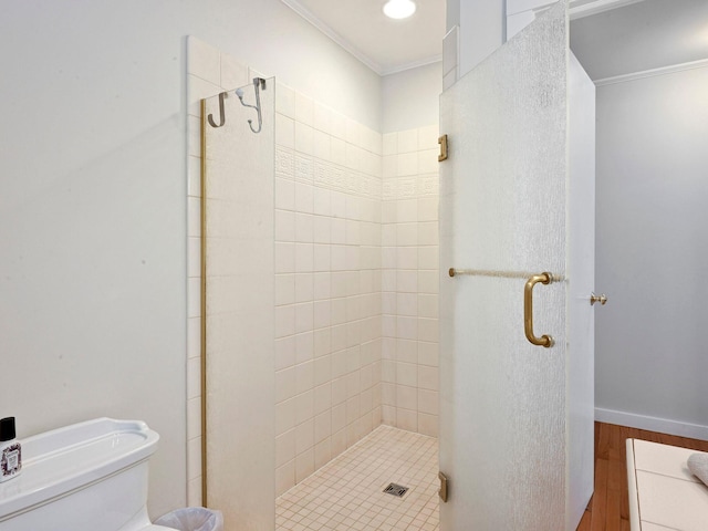 bathroom featuring ornamental molding, an enclosed shower, and toilet