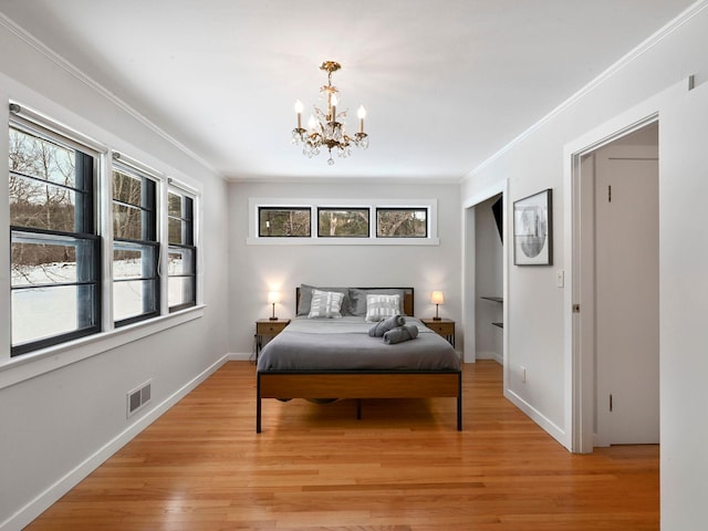 bedroom featuring ornamental molding, a chandelier, and light wood-type flooring